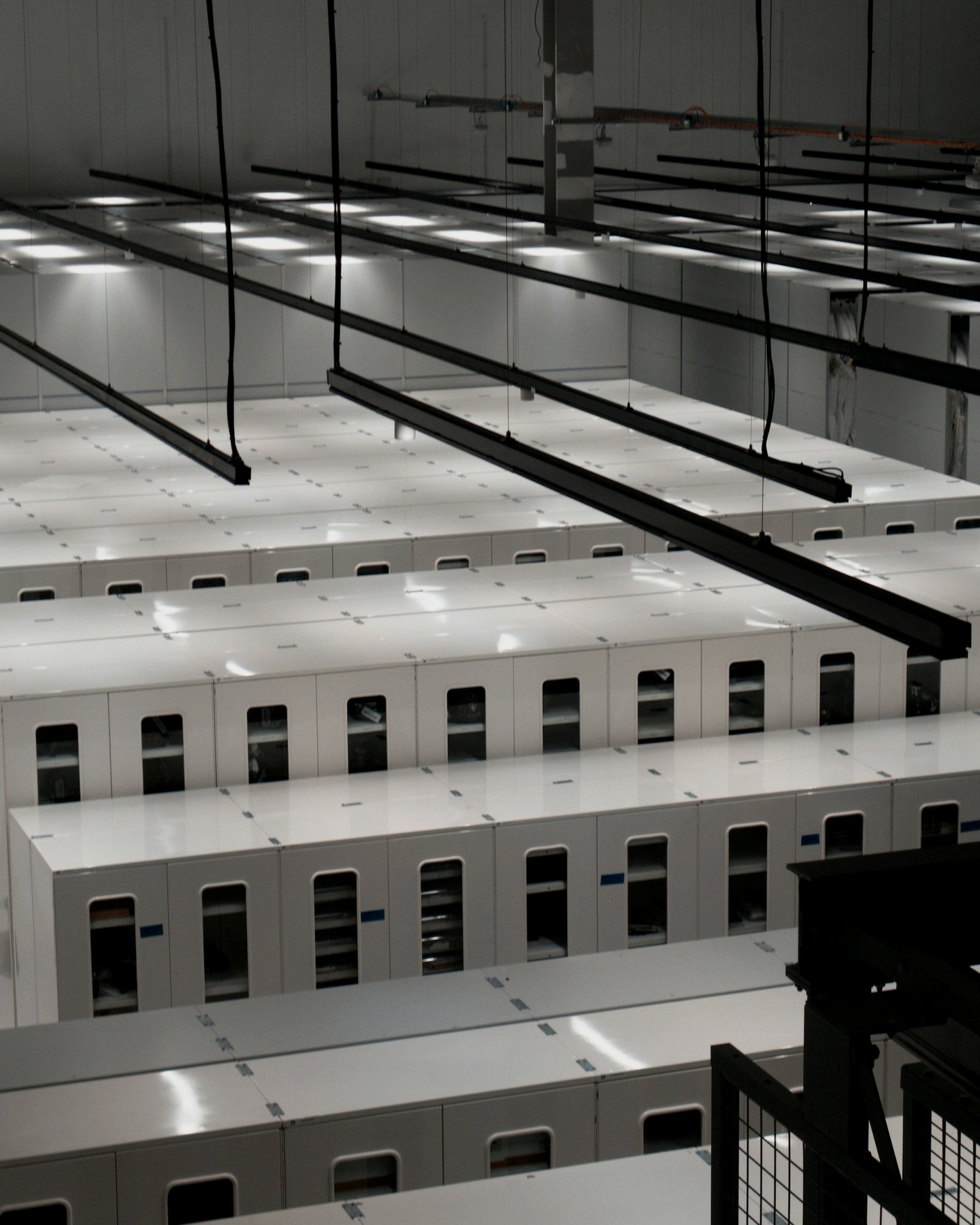 Rows of white server cabinets in a data center hall
