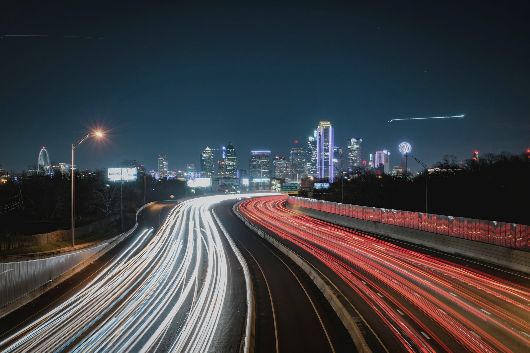 Traffic light trails on a highway into the city at night