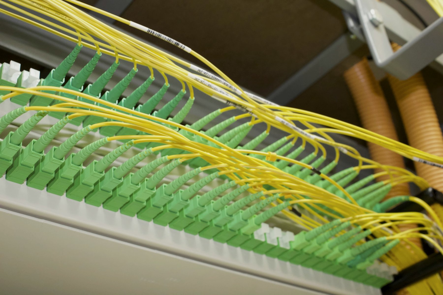 Yellow fiber optic cables on a patch panel